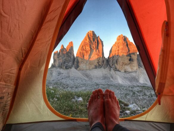 person camping in tent near mountains